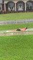 Guy Slides on Flooded Pavement While Lying on Pool Float
