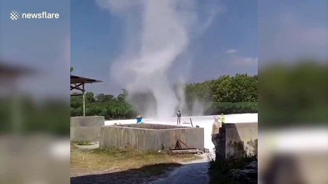 Workers try to fight dust devil tornado ripping through flour processing plant in Indonesia