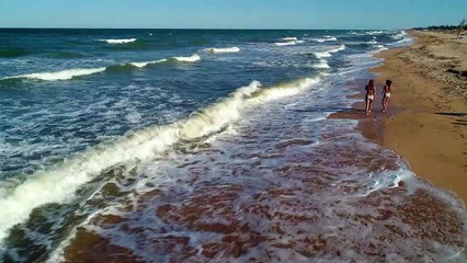 girls-walking-on-the-sand-next-to-the-sea-waves-14567-medium