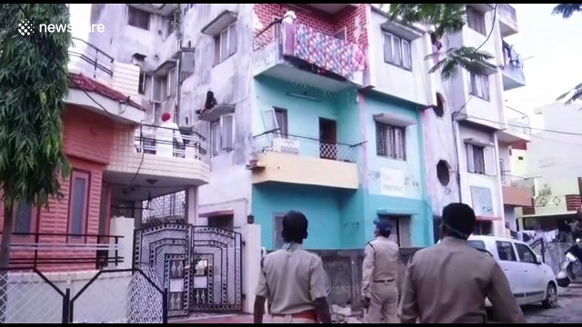 Shocking moment Indian woman threatened to jump off high ledge after alleged family dispute
