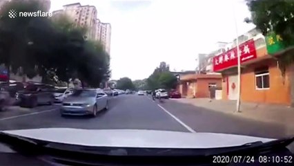 Girl falls from moving scooter in front of car on busy road in China