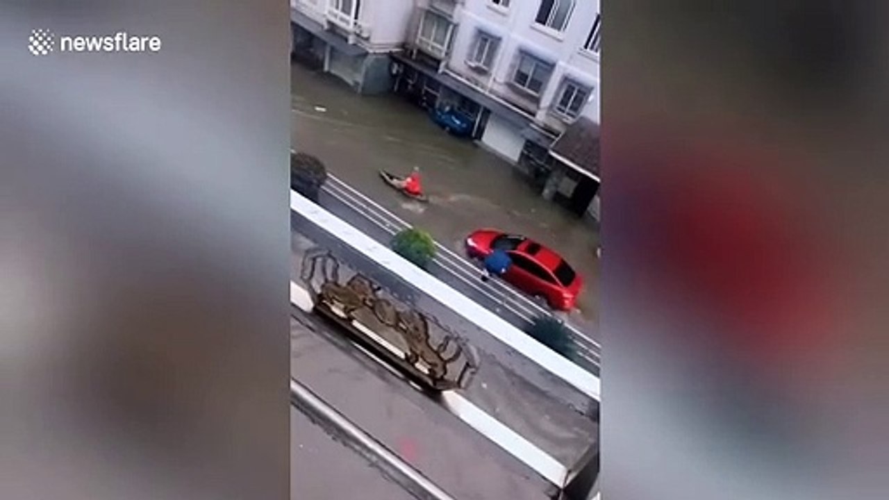 Chinese man rows across flooded streets to get...