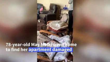 Elderly woman finds solace in music amidst destruction