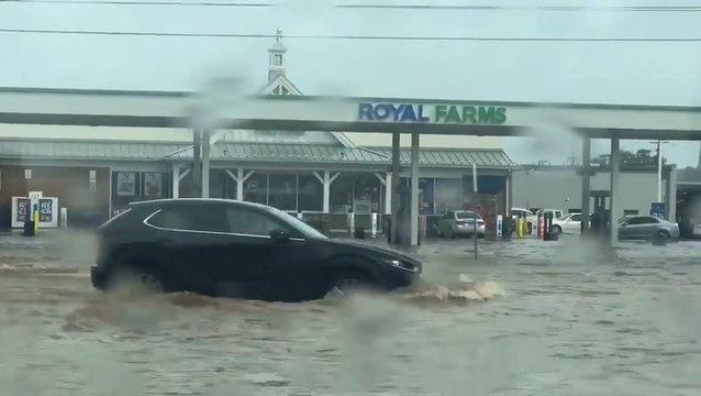Motorists plow through deep floodwaters
