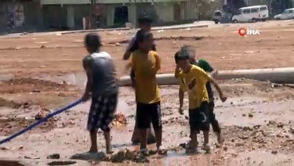 Sıcaktan bunalan çocuklar çamurda halay çekip hortumla serinledi