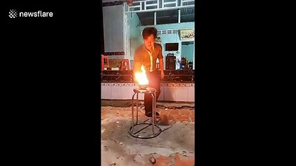Vietnamese street performer eats burning charcoal in fiery display
