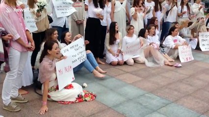 A group of young women sing and hold flowers during protests in Belarus