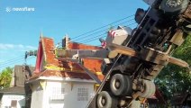 Bungling crane operator knocks over 50ft high chimney and crushes sacred Buddhist crematorium
