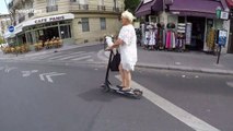 Pet parrot rides on scooter handlebars in the streets of Paris