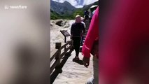 Woman deliberately pushes over warning boards and bins at Chinese scenic spot