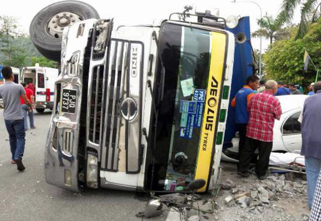 Woman killed after lorry flips, spills load of crushed rocks on car