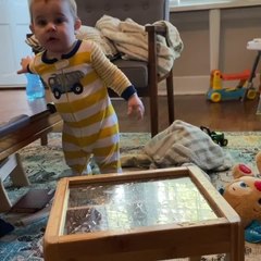 Toddler Drinks Spilt Water Off Glass Table