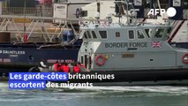 Des migrants sont escortés par les autorités britanniques dans le port de Douvres