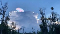 Un magnifique nuage arc-en-ciel apparait derrière les nuages