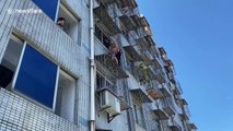 Chinese man holds up 4-year-old boy hanging from fifth-floor window