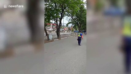 River overflows onto road after heavy rain in the Philippines