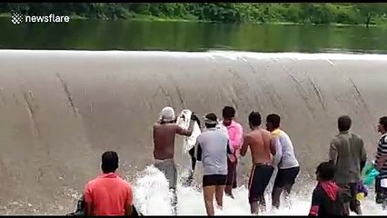 Indian villagers take advantage of flood waters to easily scoop up fish