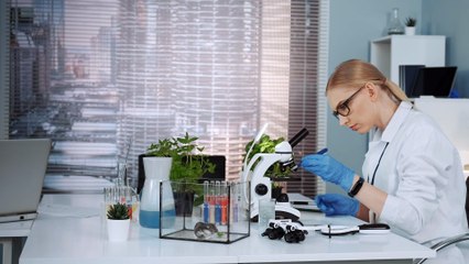 smart-female-scientist-in-lab-coat-working-with-mi-ZA4MRJK