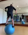 Man Weight Trains With Gripbells While Balancing on Stability Ball
