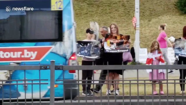 Women hold pictures of injuries sustained by protesters during rally in Minsk