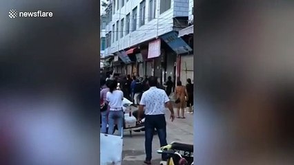 Chinese crowd hold bedsheet to catch 5-year-old thrown out of burning flat by mother