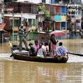 People use boat to commute in a flooded locality in Midnapore