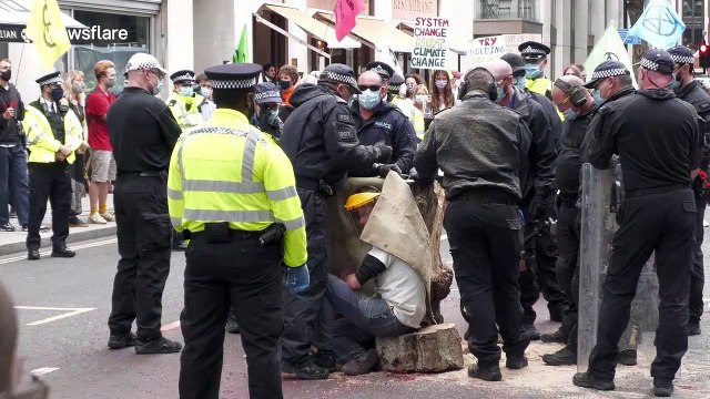 Extinction Rebellion protesters lock themselves to tree trunk outside Home Office in London