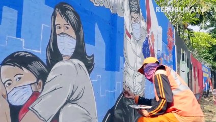 Petugas PPSU Bukit Duri menyelesaikan pembuatan mural yang berisi pesan waspada penyebaran virus Corona di Bukit Duri, Jakarta.