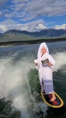 Woman Casually Drinks Coffee And Reads Magazine While Wakesurfing