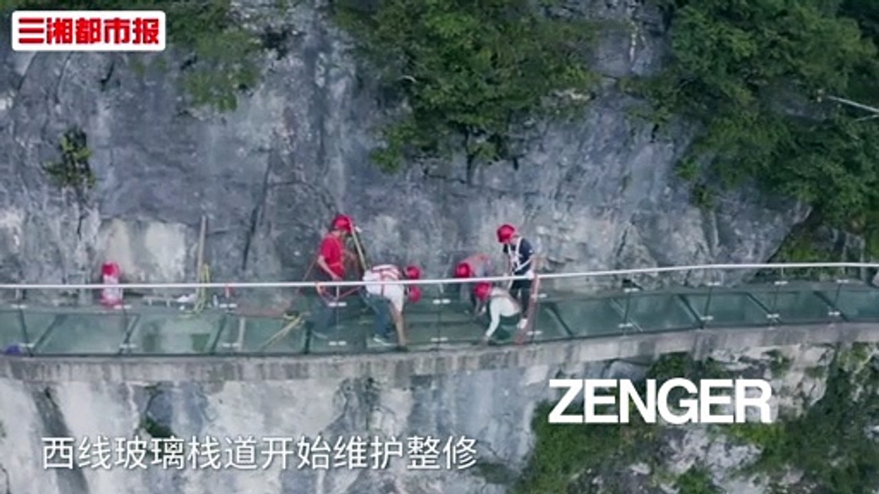 Workers replace glass panels on scenic mountain path