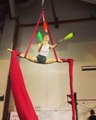 Woman Does Split While Hanging From Aerial Silks and Juggles