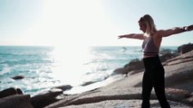 Woman Meditating In Yoga Warrior Pose At The Ocean, Beach  And Rock Mountains. Yoga Pose