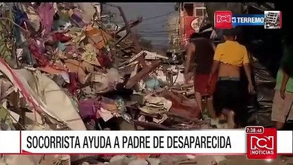 Un socorrista ayuda a un padre a buscar a su hija tras terremoto en Ecuador