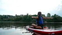 Beautiful Woman Does Yoga Routine On Paddle Board In River