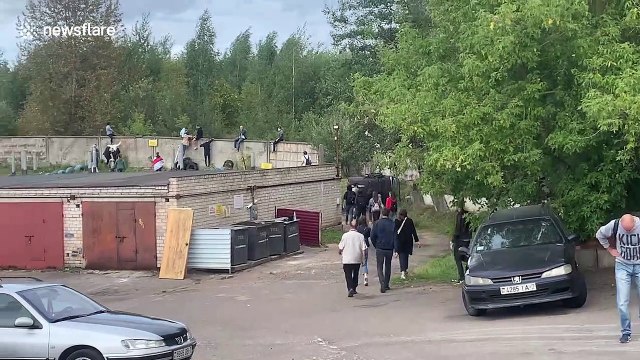 Peaceful protesters in Minsk climb through barbed wire and over walls to get away from riot police