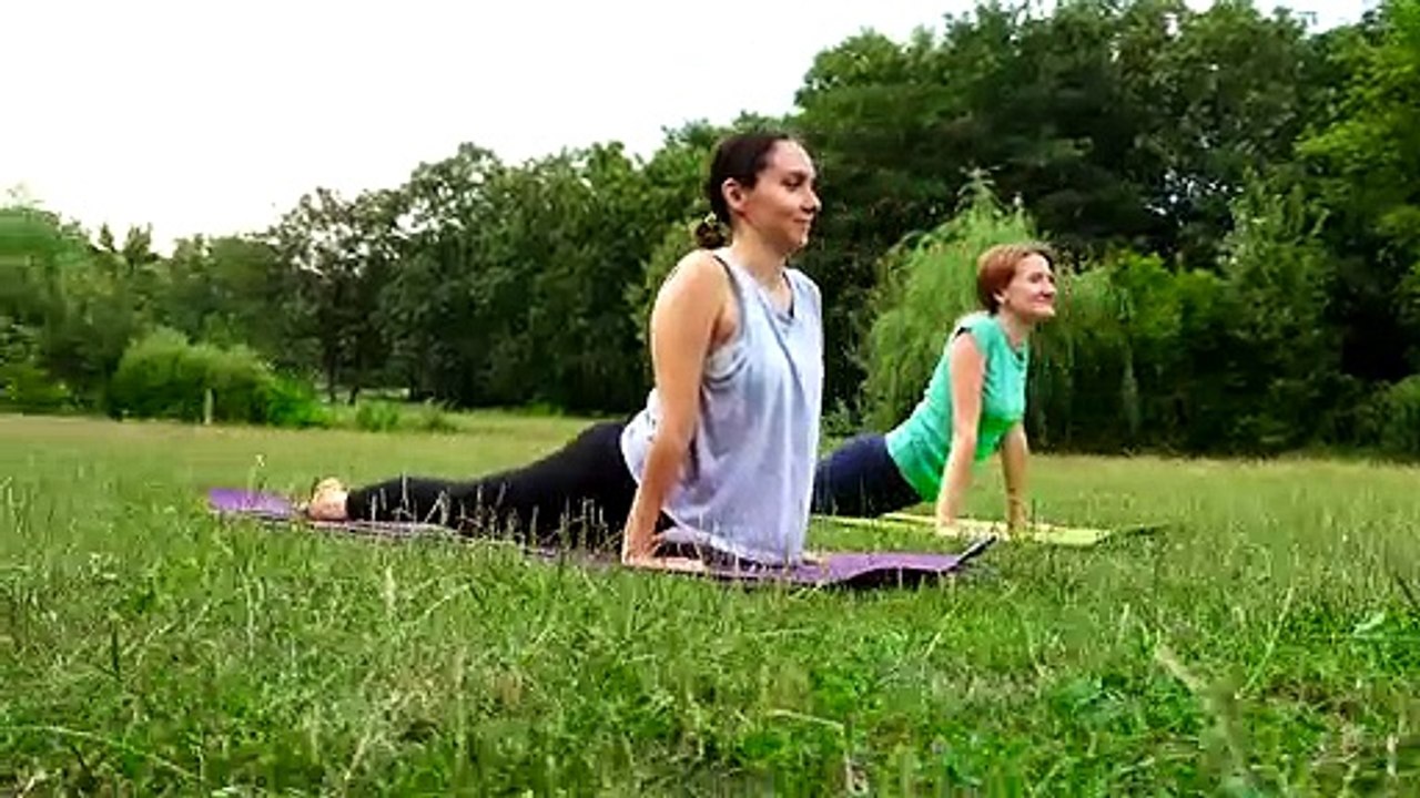 Two Beautiful Woman Practicing Yoga In The Park.