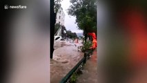 Firefighters rescue passengers trapped on bus roof after flood submerges road in southern China