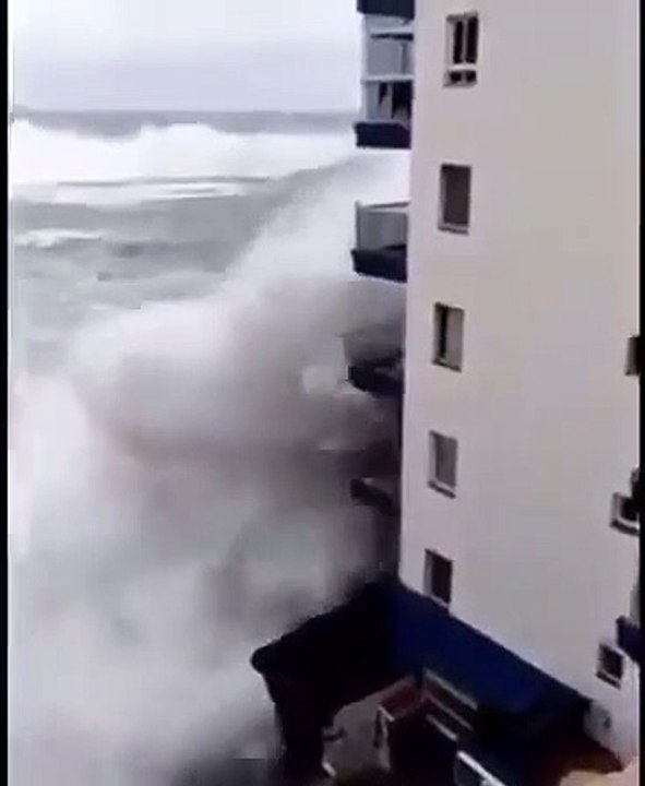 Ocean wave hits the building terrace