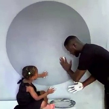 Il dessine un portrait de cette petite fille en jouant avec ses mains couvertes de peinture