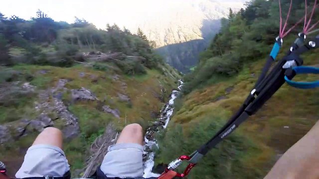 Speed flyer follows river down Austrian Alps inches away from treetops