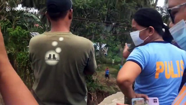 Locals use make-shift pulley to cross bridge which collapsed during storms in the Philippines