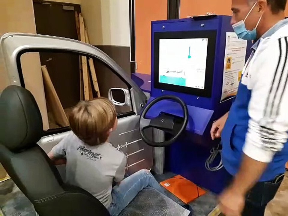Heigy, élève de CM2, lutte avec une portière de voiture dans le simulateur d'inondation à Sarrians (Vaucluse)