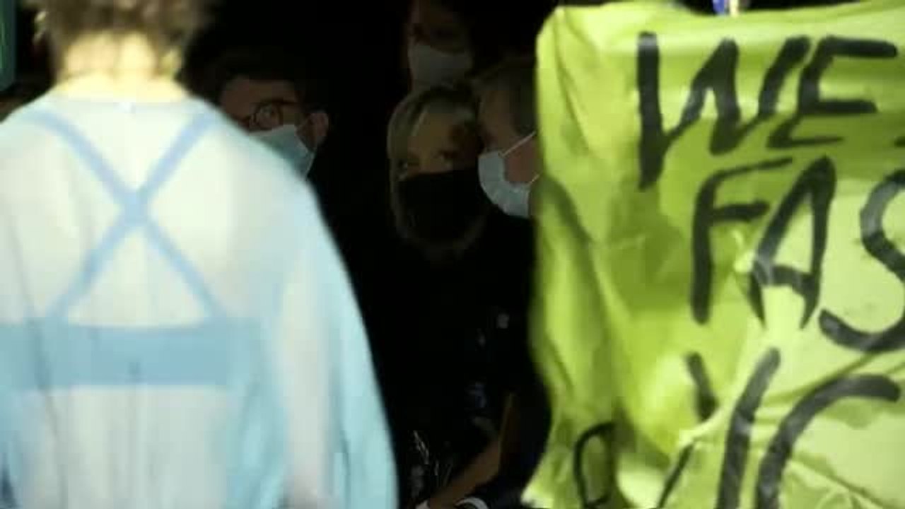 Una manifestante se sube a la pasarela en la Semana de la Moda de París