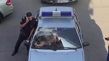 Une femme explose le pare-brise d'une voiture de police