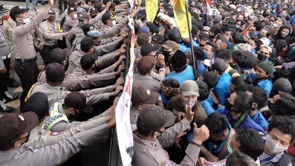 Indonesian police fire tear gas as thousands of people protest against new labour law