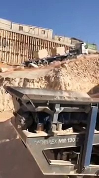 Une pelleteuse stoppe un camion