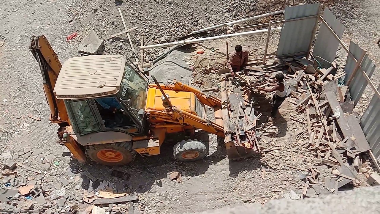 JCB backho loader loading Dump Truck From Hlep labour.