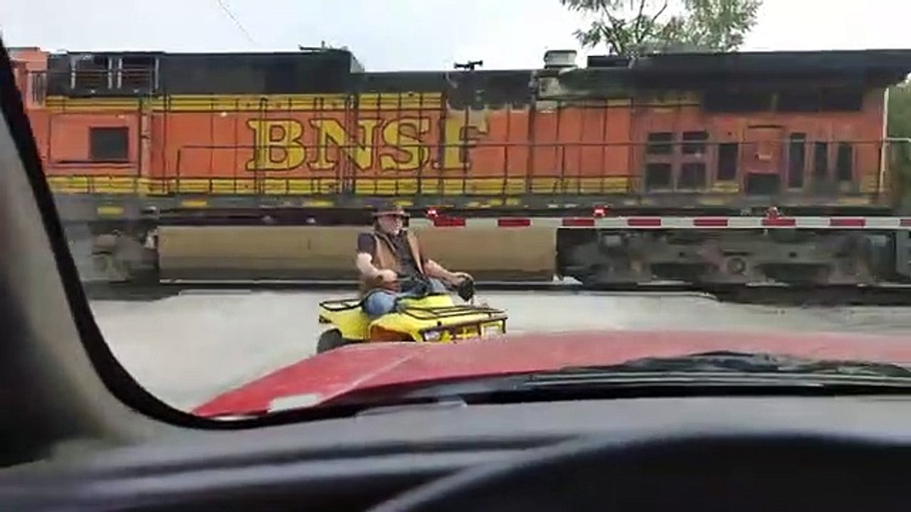 Cet homme en quad traverse la voie ferrée avec son chien et évite le pire de justesse