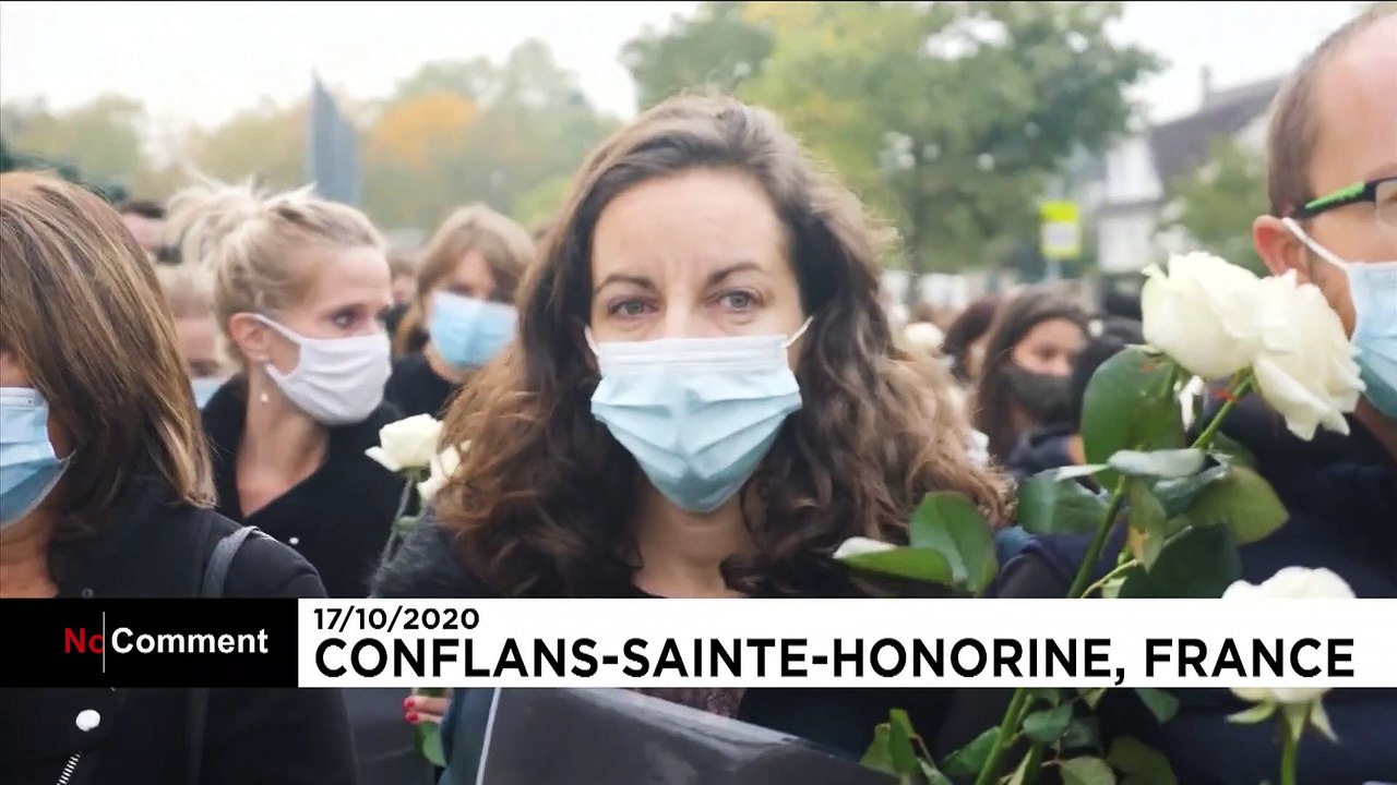 People pay tribute to beheaded teacher outside school where attack took place