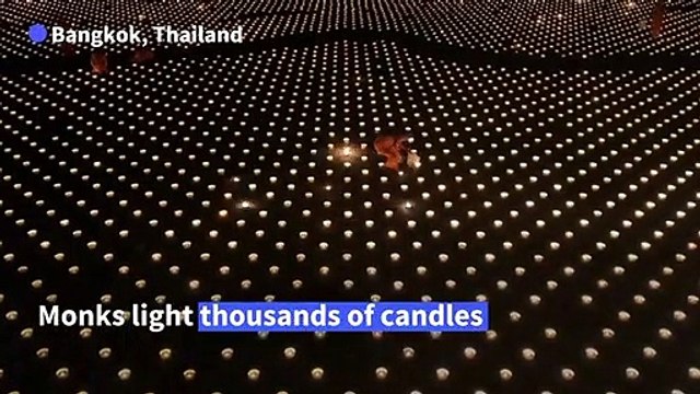 Thailand: Buddhist monks light candles on Visakha Bucha Day